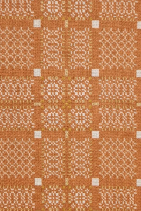 Melin Tregwynt Wool throw with an orange and white woven Knot Garden pattern - front