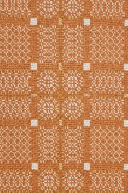 Melin Tregwynt Wool throw with an orange and white woven Knot Garden pattern - front