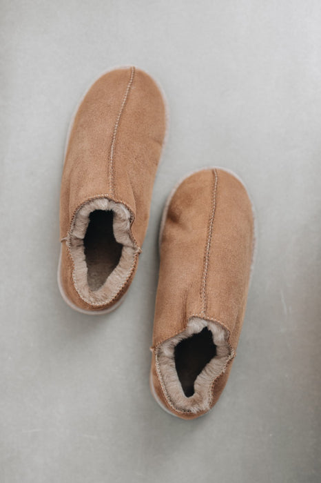 Luxury women’s shearling slippers in tan suede for all-day comfort.