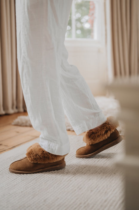 Slipper on the foot of a lady walk around the house in a chestnut colour