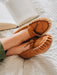 Ava Women's Real Sheepskin Moccasins worn by model with feet up on a bed reading a book 