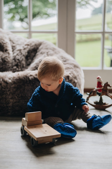 little boy playing wearing sheepskin boots