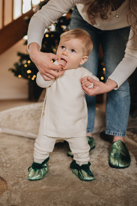 little boy wearing green boots and mum wearing green cadi sheepskin slippers 