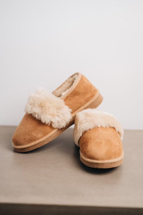 Warm shearling-lined women’s sheepskin slippers with durable hard soles for indoor and outdoor use.