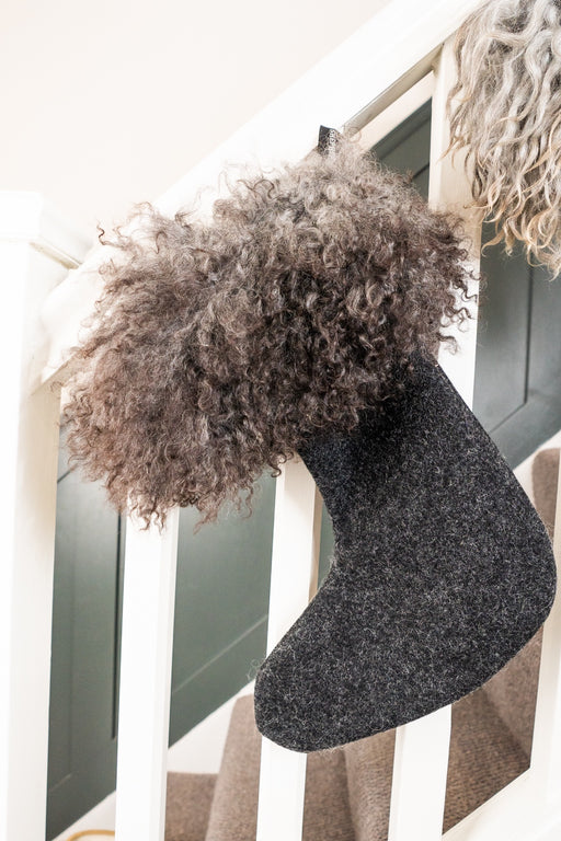 A brown and grey sheepskin and wool stocking. A curly Gotland Sheepskin cuff with a wool boot shape stocking bottom.